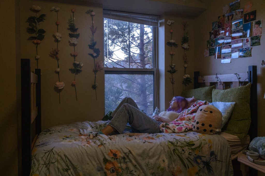 Natalie laying on bed looking out window